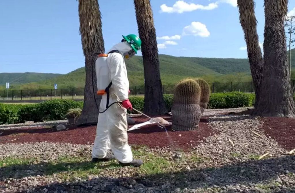 persona con traje de seguridad haciendo control fitosanitario