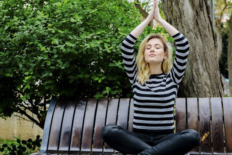 persona meditando en área verde